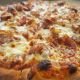 Extreme close-up capturing the melted cheese and crispy pepperoni on a wood-fired pizza. The macro perspective emphasizes the caramelization and texture, while selective focus draws attention to the bubbling mozzarella.